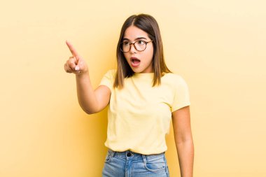 Oldukça İspanyol bir kadın şaşkın ve şaşırmış hissediyor, şaşırmış ve hayranlıkla yukarı bakıyor, şaşkın, açık ağızlı bir bakışla