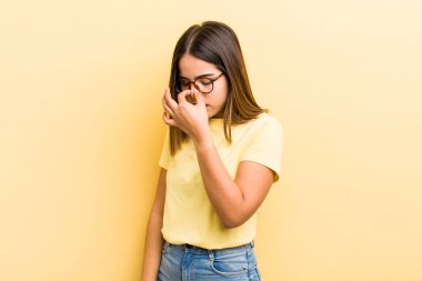 Güzel İspanyol bir kadın stresli, mutsuz ve hayal kırıklığına uğramış, alınına dokunmuş ve şiddetli baş ağrısı çeken.