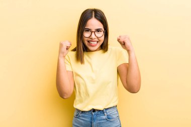 Güzel İspanyol bir kadın mutlu, pozitif ve başarılı hissediyor, zaferi, başarıları veya iyi şansı kutluyor.