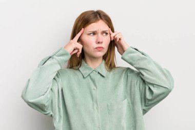 Kızıl saçlı, güzel bir kadın kafası karışık ya da şüpheci, bir fikre odaklanmış, çok düşünüyor, kenarda boşluğu kopyalamak istiyor.