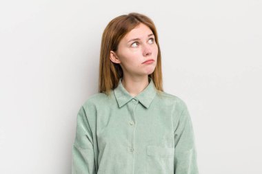 Endişeli, kafası karışık, budala bir ifadeyle kırmızı saçlı, güzel bir kadın, kopya alanı arıyor, şüpheci.