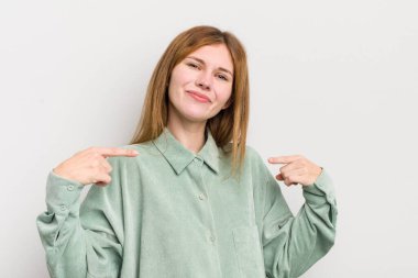 Kızıl saçlı güzel bir kadın gururlu, kibirli, mutlu, şaşırmış ve tatmin olmuş görünüyor, kendini gösteriyor, kendini kazanan gibi hissediyor.