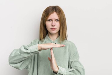 Kızıl saçlı güzel kadın ciddi, sert, kızgın ve canı sıkkın görünüyor.