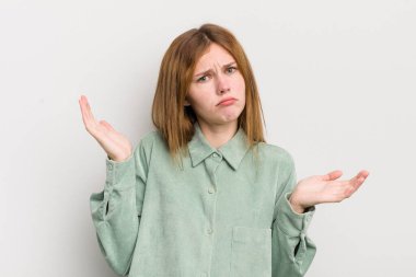 Şaşkın, kafası karışmış ve stresli görünen kızıl saçlı güzel bir kadın. Farklı seçenekler arasında merak ediyor. Belirsiz hissediyor.