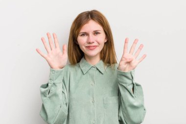 Kızıl saçlı güzel bir kadın gülümsüyor ve arkadaş canlısı görünüyor. Dokuz ya da dokuzuncu eli önde, geriye doğru sayıyor.