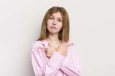 Kızıl saçlı güzel kadın şaşkın ve şaşkın görünüyor, güvensiz ve zıt yönlere şüpheyle bakıyor.