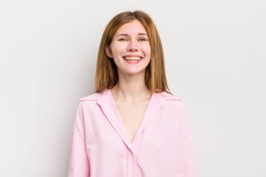 Kızıl saçlı güzel kadın mutlu ve şapşal görünüyor. Geniş, eğlenceli, kaçık bir gülüşü ve açık gözleri var.