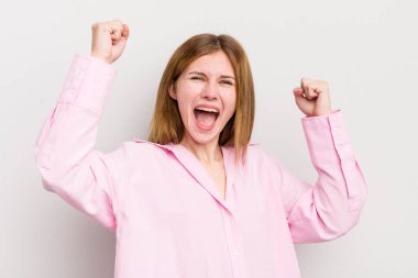 Kızıl saçlı güzel kadın zafer çığlıkları atıyor. Heyecanlı, mutlu ve şaşırmış görünüyor. Kutlama yapıyor.