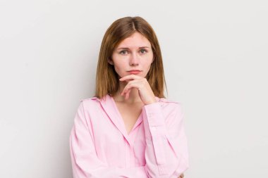 Kızıl saçlı güzel kadın ciddi görünüyor, kafası karışık, kararsız ve düşünceli, seçenekler ve seçenekler arasında şüpheci.