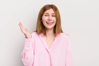 kızıl saçlı güzel bir kadın mutlu, şaşırmış ve neşeli, olumlu bir tavırla gülümseyen, bir çözüm ya da fikir gerçekleştiren.