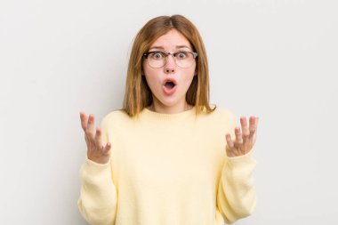 Kızıl saçlı güzel bir kadın şok olmuş ve şaşırmış, endişeli ve paniklemiş, stresli ve dehşete kapılmış bir bakışla