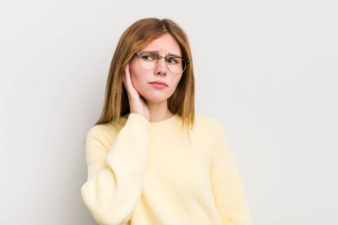 Kızıl saçlı güzel kadın ciddi ve meraklı görünüyor, dinliyor, gizli bir konuşma veya dedikodu duymaya çalışıyor, kulak misafiri oluyor.