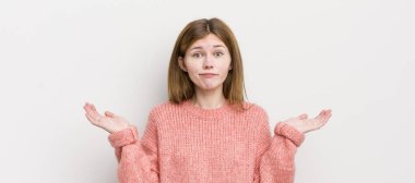 Kızıl saçlı güzel kadın şaşkın ve kafası karışık, şüpheci, farklı seçenekleri tartıyor ya da komik ifadeli seçiyor.