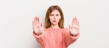 Kızıl saçlı güzel kadın ciddi, mutsuz, kızgın ve hoşnutsuz görünüyor. Girmeyi yasaklıyor ya da her iki avucunun içinde de dur diyor.