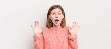 Kızıl saçlı güzel bir kadın mutlu, heyecanlı, şaşırmış ya da şok olmuş, gülümseyen ve hayrete düşmüş.