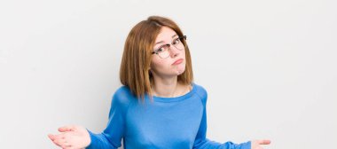 red head pretty woman feeling clueless and confused, having no idea, absolutely puzzled with a dumb or foolish look