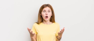 Kızıl saçlı güzel bir kadın şok olmuş ve şaşırmış, endişeli ve paniklemiş, stresli ve dehşete kapılmış bir bakışla