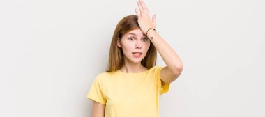 red head pretty woman raising palm to forehead thinking oops, after making a stupid mistake or remembering, feeling dumb