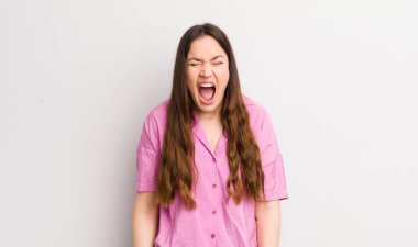 pretty caucasian woman shouting aggressively, looking very angry, frustrated, outraged or annoyed, screaming no