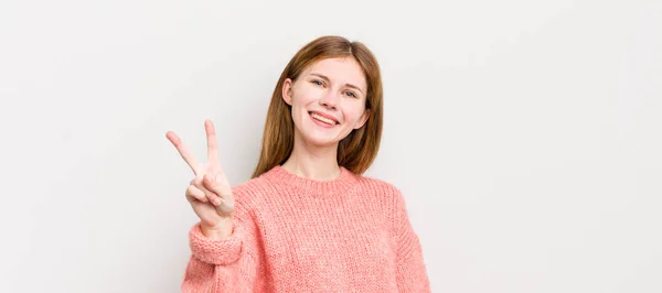 Rote Kopf Hübsche Frau Lächelt Und Sieht Freundlich Zeigt Nummer — Stockfoto