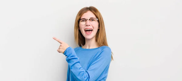 Red Head Pretty Woman Looking Excited Surprised Pointing Side Upwards — Stock Photo, Image