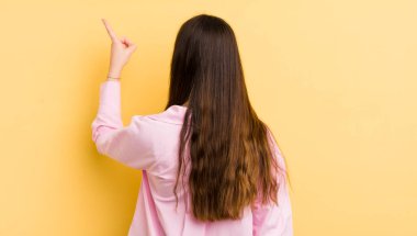 Güzel beyaz kadın, dikiz aynası ve fotokopi alanında duran ve objeyi işaret eden.