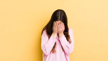 pretty caucasian woman feeling sad, frustrated, nervous and depressed, covering face with both hands, crying