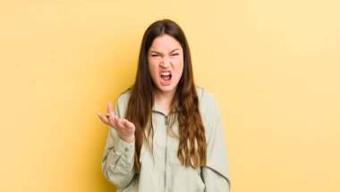pretty caucasian woman looking angry, annoyed and frustrated screaming wtf or whats wrong with you 
