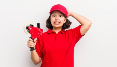 Güzel İspanyol kız stresli, endişeli ya da korkmuş, elleri başının üstünde. paketleyici kavramı