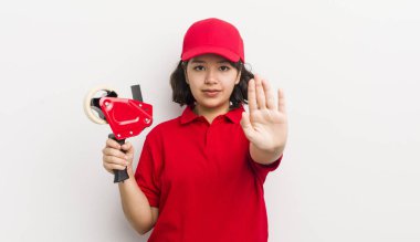 Güzel İspanyol kız ciddi görünüyor. Avuç içini gösteriyor. Durdurma hareketi yapıyor. paketleyici kavramı