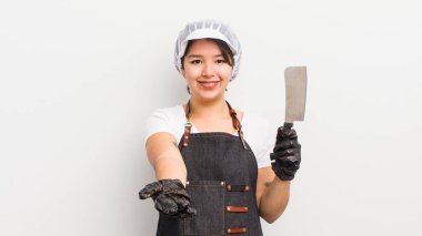 Şirin İspanyol kız arkadaşça gülümsüyor ve bir konsept sunuyor. Kasap konsepti