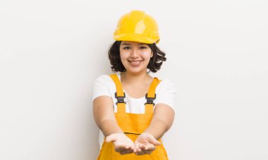 Şirin İspanyol kız arkadaşça gülümsüyor ve bir konsept sunuyor. işçi konsepti