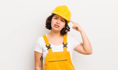 Kafası karışmış, kafası karışmış, deli olduğunu gösteren güzel bir İspanyol kız. işçi konsepti