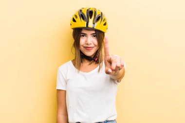 Güzel İspanyol kız gülümsüyor ve arkadaş canlısı görünüyor, bir numarayı gösteriyor. motor konsepti