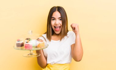 Güzel İspanyol kız şok olmuş, gülüyor ve başarıyı kutluyor. Ev yapımı kek konsepti