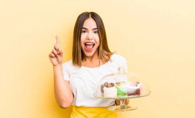 Güzel İspanyol bir kız bir fikri fark ettikten sonra mutlu ve heyecanlı bir dahi gibi hissediyor. Ev yapımı kek konsepti