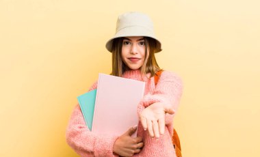 Şirin İspanyol kız arkadaşça gülümsüyor ve bir konsept sunuyor. öğrenci konsepti