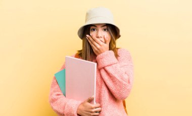 Güzel İspanyol kız şok olmuş bir şekilde ağzını eliyle kapatıyor. öğrenci konsepti