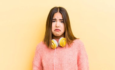 Tatlı İspanyol kız üzgün ve mızmızlanıyor. Mutsuz bir bakışı var ve ağlıyor. kulaklık konsepti