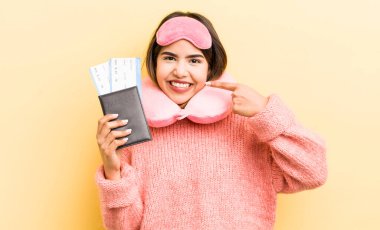 Güzel İspanyol kız kendine güvenerek kendi gülüşünü işaret ediyor. uçuş yolcu kavramı