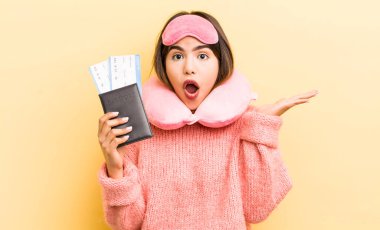 Güzel İspanyol kız şaşırmış ve şok olmuş görünüyor. Çenesi düşmüş ve elinde bir nesne var. uçuş yolcu kavramı