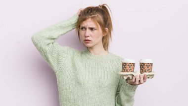 Kızıl saçlı güzel kız şaşkın ve kafası karışık, kaşınan kafa. kahve konseptini kaldır.