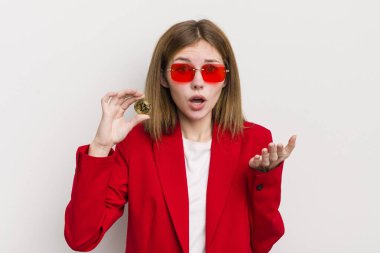 Kızıl saçlı güzel kız çok şaşırmış ve şok olmuş hissediyor. Bitcoin konsepti