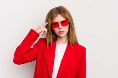 Kızıl saçlı güzel kız kafası karışık ve şaşkın hissediyor, deli olduğunu gösteriyor.