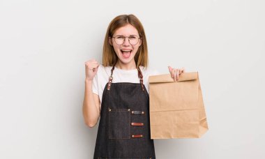 Kızıl saçlı güzel kız şokta, gülüyor ve başarıyı kutluyor. çalışanı götür.