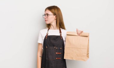 Profil görünümlü kızıl saçlı güzel kız hayal mi kuruyor yoksa hayal mi kuruyor? çalışanı götür.