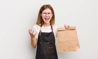 Kızıl saçlı güzel kız sinirli, sinirli ve sinirli görünüyor. çalışanı götür.