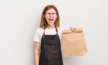 Kızıl saçlı güzel kız agresif bir şekilde bağırıyor, çok kızgın görünüyor. çalışanı götür.