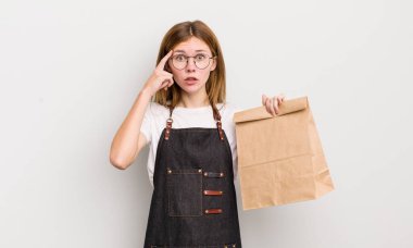 Kızıl saçlı güzel kız şaşırmış görünüyor, yeni bir düşünceyi, fikri ya da konsepti fark ediyor. çalışanı götür.