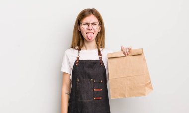 Kızıl saçlı güzel kız iğrenmiş ve sinirlenmiş hissediyor ve dilini dışarı çıkarıyor. çalışanı götür.